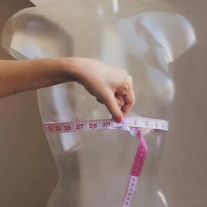 Foto de Woman using a tape measure to make bust measurement in inches do  Stock